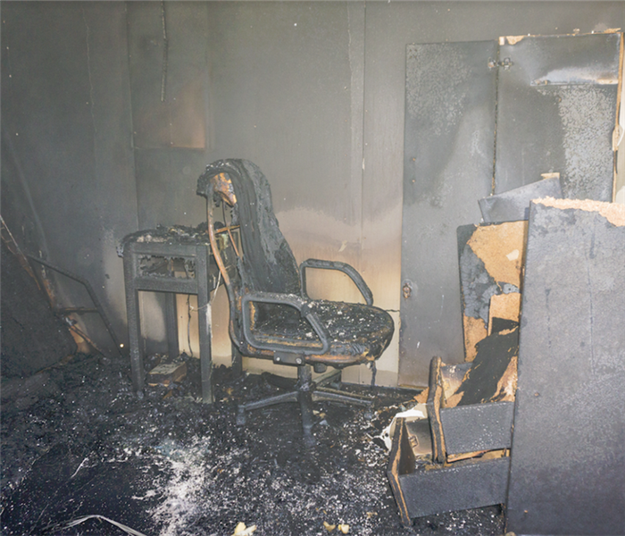 a fire damaged bedroom with soot and debris everywhere
