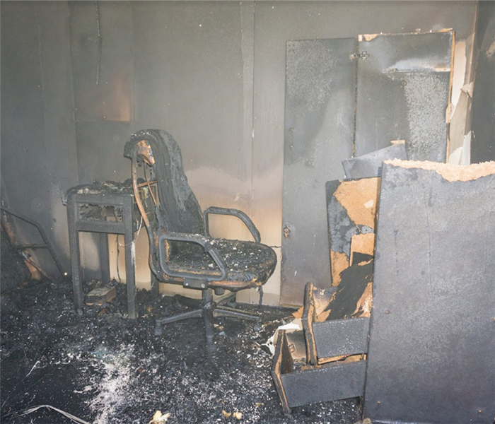 a fire damaged room with debris everywhere and soot covering everything
